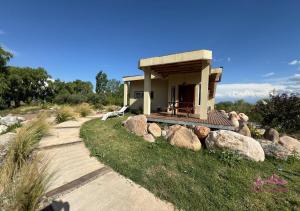 a small house with a porch and some rocks at Los Rosandes in Los Sauces
