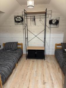 a room with two beds and a wooden floor at Les Rolliannes Maison au village in Surques