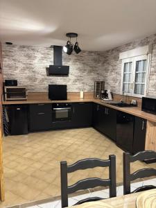 a kitchen with a counter and two chairs in it at Les Rolliannes Maison au village in Surques +3 photos