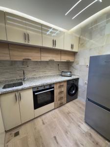 a kitchen with white cabinets and a refrigerator at Appartement Dar LALA 1 in Fez