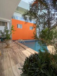 einem Pool in einem Gebäude mit orangefarbener Wand in der Unterkunft Aigrettes in Somone