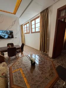 a living room with a table and a tv at Appartement Dar LALA 1 in Fez