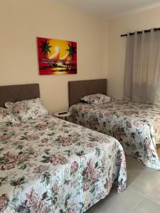 a bedroom with two beds and a painting on the wall at Loft incrível e completo in São Lourenço do Sul +9 photos