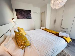 a bedroom with a large white bed with yellow pillows at Lovely 1 bedroom apartment w balcony&parking-BON10 in Luxembourg