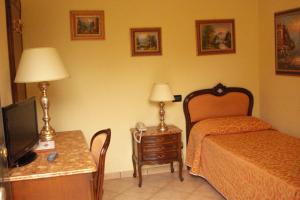 una camera d'albergo con letto e scrivania con TV di Magnagallo a Campogalliano