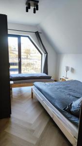 zwei Betten in einem Zimmer mit großem Fenster in der Unterkunft Stodoła pod Bacówką Zawoja Sauna Jacuzzi in Skawica