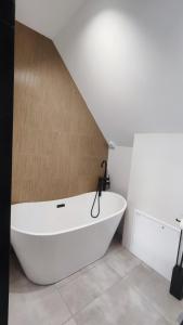 eine große weiße Badewanne im Bad mit einer Treppe in der Unterkunft Stodoła pod Bacówką Zawoja Sauna Jacuzzi in Skawica + 35 Fotos