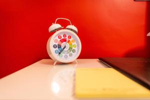 an alarm clock sitting on top of a book at Luxury En-Suite Room 3 in Blewbury Oxfordshire in Blewbury