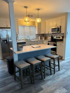 坦纳斯维尔Modern 3BR Townhouse Near Kalahari, Aquatopia & Great Wolf的厨房里有一个带吧台凳的大岛台