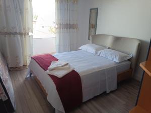 ein Schlafzimmer mit einem Bett mit weißen Laken und einem Fenster in der Unterkunft Casa Praia Brava Florianópolis. in Florianópolis + 41 Fotos