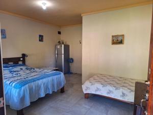 a bedroom with two beds and a refrigerator at La-Tica in Horquetas