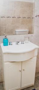 ein Badezimmer mit einem weißen Waschbecken und einem Spiegel in der Unterkunft Cabaña Morada del Cerro - Cabaña Chañar - in Capilla del Monte + 20 Fotos