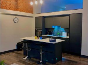 a kitchen with a counter and a clock on the wall at Chic Central, Relaxing, Restful, Retreat, Heated Floors, High Ceiling, Open Plan, City Centre, 1BR in Sheffield