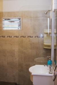 ein Badezimmer mit Waschbecken und Toilette und einem Fenster in der Unterkunft Cabaña Morada del Cerro - Cabaña Chañar - in Capilla del Monte