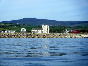 a house on the shore of a body of water at Shore Hotel in Port Saint Mary