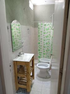 Un baño con inodoro, lavabo y espejo. en ricardo, en Mar de Ajó