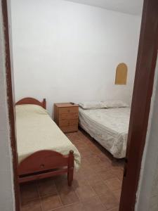 1 dormitorio con 2 camas, tocador y espejo en ricardo, en Mar de Ajó