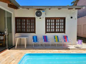 a group of chairs and a table next to a house at Casa 3 Quartos 5 min Centro 15 min aeroporto in Foz do Iguaçu
