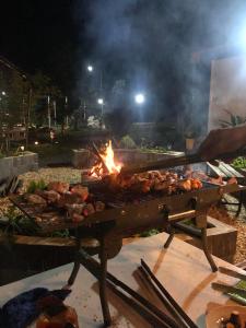 a person cooking food on a grill at night at Huong Sen Garden lodge in Xóm Bãi Trại