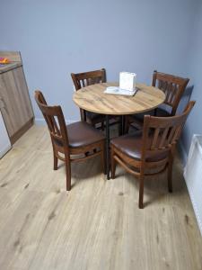 a wooden table with chairs and a table and a table at Apartment 2 at busy bee in Daingean
