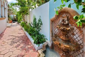 a fountain on the side of a wall with plants at Casa Tortuga Ocean Park Villa in San Juan