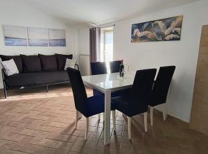 a living room with a table and chairs and a couch at Appartamento la casa di Mary Anguillara Sabazia-Lago,Relax e Roma a portata di treno in Anguillara Sabazia