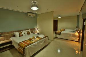 um quarto de hotel com duas camas e uma mesa em Paiaguas Palace Hotel em Cuiabá