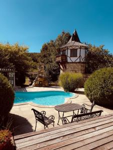 a swimming pool with a table and a house at Chalet d'Argent in Dobreni