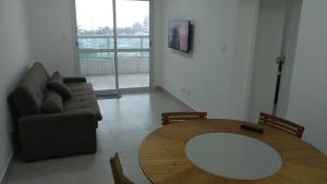 a living room with a table and a couch at Apartamento praia grande frente do mar in Praia Grande