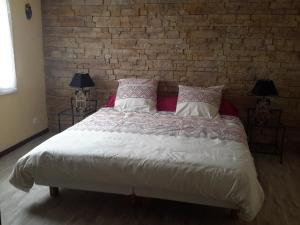 a bedroom with a large bed with a brick wall at Les Granges in Villars