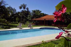 a swimming pool with two chairs and a house at Pantanal Ranch Meia Lua in Esperança