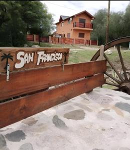 a wooden bench with a sign that reads san francisco at Cabañas Del Rio in San Francisco del Monte de Oro