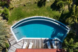 an overhead view of a swimming pool with chairs and grass at Villa Calico in Grand-Bourg