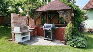 a barbecue grill and a gazebo in a yard at Moderne und ruhige Ferienwohnung in Feuchtwangen