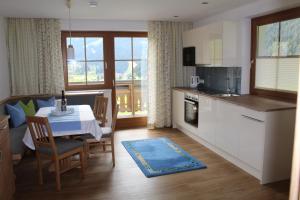 a kitchen and dining room with a table and a kitchen and a room with at Haus Sonnwinkl in Filzmoos