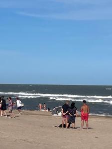 a group of people standing on the beach at Fedes house in Villa Gesell