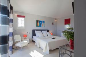 ポルト・ヴェッキオにあるChambres d'hôtes Casa di l'Oruのベッドルーム(白いベッド1台、ガラスのテーブル付)