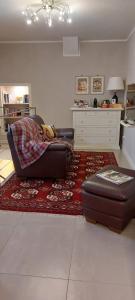 Linda's Holiday Home في روكاسترادا: غرفة معيشة مع أريكة وسجادة