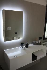 a bathroom with a white sink and a mirror at The One Malpensa Rooms in Vizzola Ticino