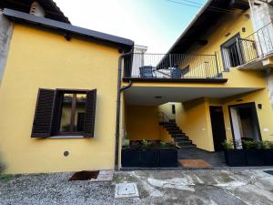 a yellow building with a staircase and a balcony at The One Malpensa Rooms in Vizzola Ticino