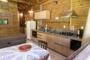 a kitchen with a table and a refrigerator at Cabana em Urubici Serra do Corvo Branco in Urubici