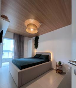 Un dormitorio con una cama con techo de madera. en Unitá Praia Grande Boqueirão, en Praia Grande