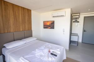 a bedroom with a white bed with a bow on it at Breeze #406 - Quádruplo vista mar por Carpediem in Tambaú +32 photos