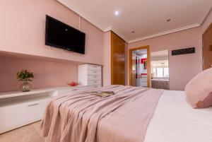 a bedroom with a bed with a tv on the wall at Estudio delante del mar la pineda in La Pineda