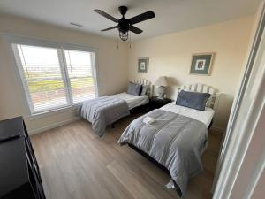a bedroom with two beds and a ceiling fan at AdmiralsView at Sea Dunes in Kitty Hawk