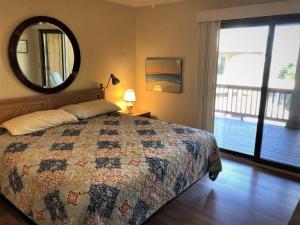a bedroom with a bed and a mirror and a window at Carolina Waves at Sea Dunes in Kitty Hawk in Kitty Hawk +28 photos