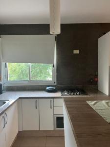 una cucina con mobili bianchi e un forno a piano cottura di Los espinillos a Mendiolaza