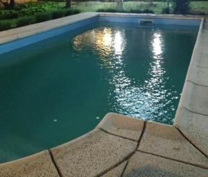 una piscina di acqua verde accanto a un marciapiede di Los espinillos a Mendiolaza