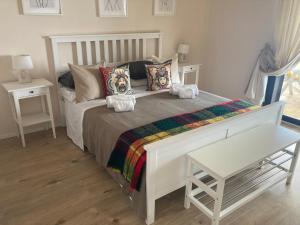 a white bed with pillows and a table in a room at Taliari Taormina Apartment in Taormina