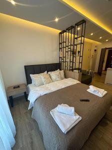 una camera da letto con un letto grande con asciugamani sopra di Apartman B64 Residence Hill Kopaonik a Kopaonik